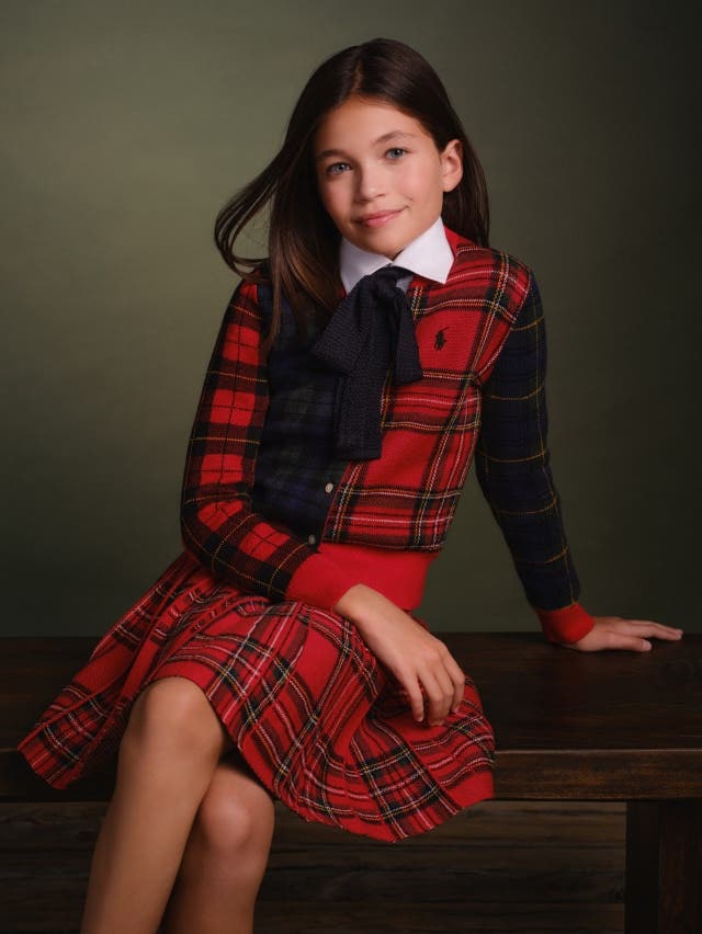 Girl in red and black plaid dress with white shirt and black bow 